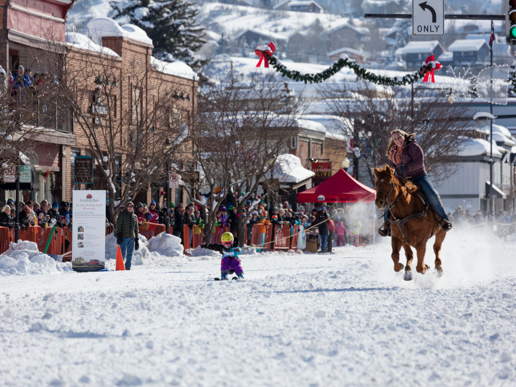 Steamboat Springs skijoring with horse towing child on skis
