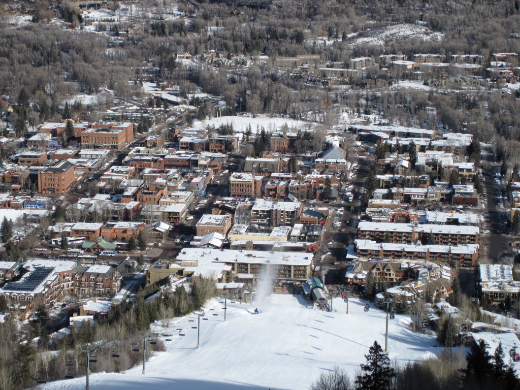 Wide photo of the city of Aspen, Colorado as seen from the mountain during winter