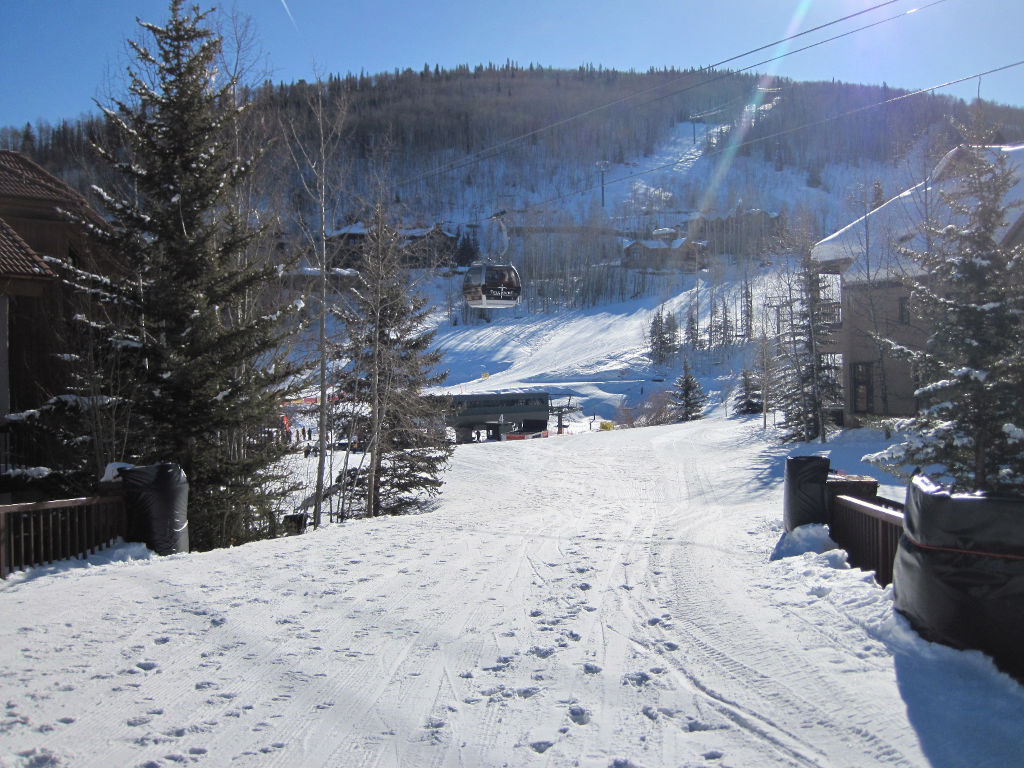 A Telluride free gondola cabin passing above the skier bridge in Mountain Village