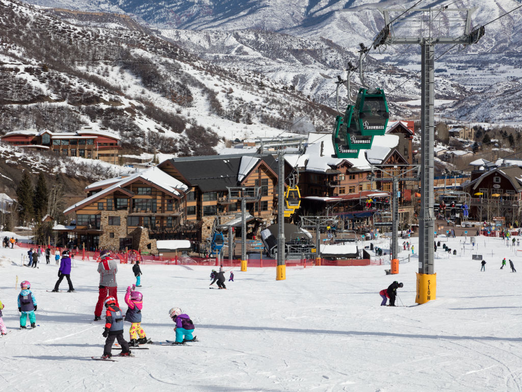 Fanny hill ski trail below Snowmass Sky Cab gondola with children's ski lesson