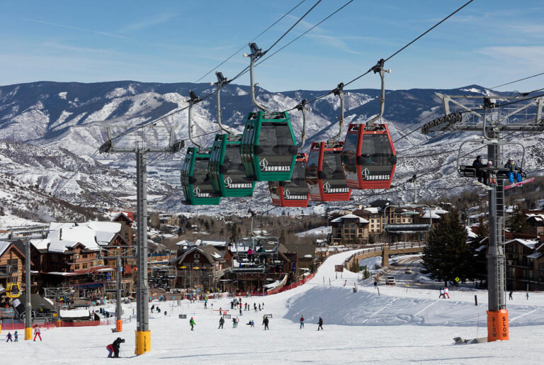 green and red cabs of the free Snowmass Sky Cab Skittles gondola above Fanny Hill ski trail